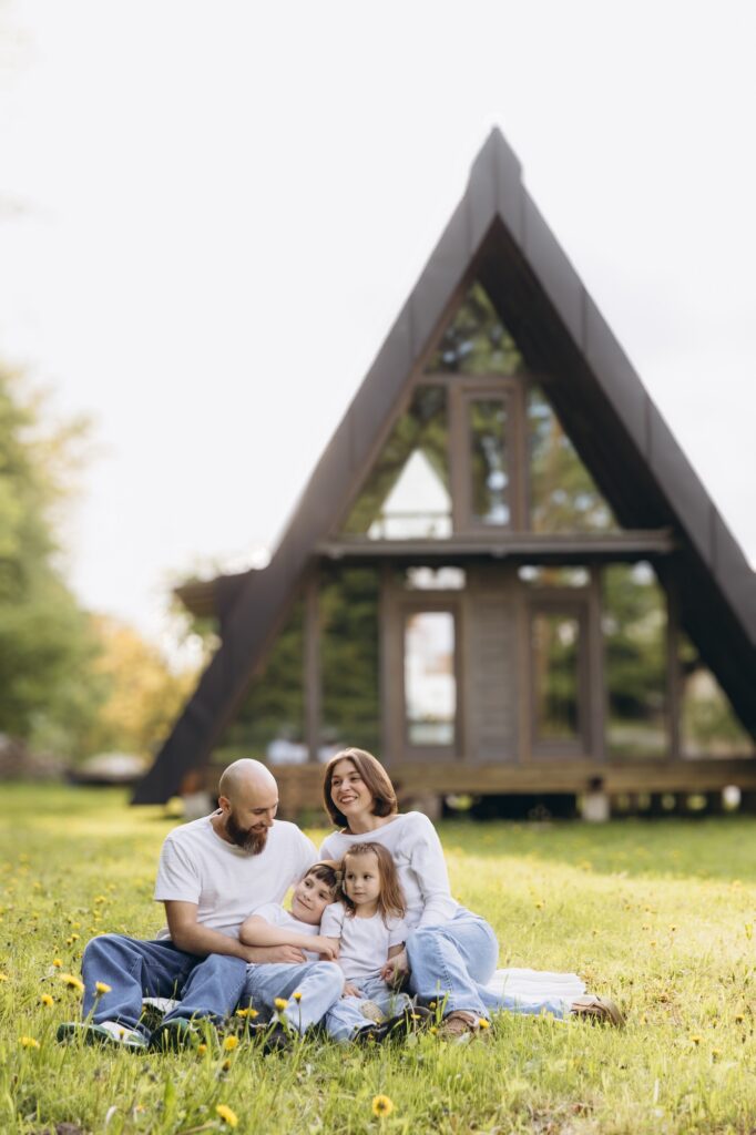 Family relaxing in front of their a frame house