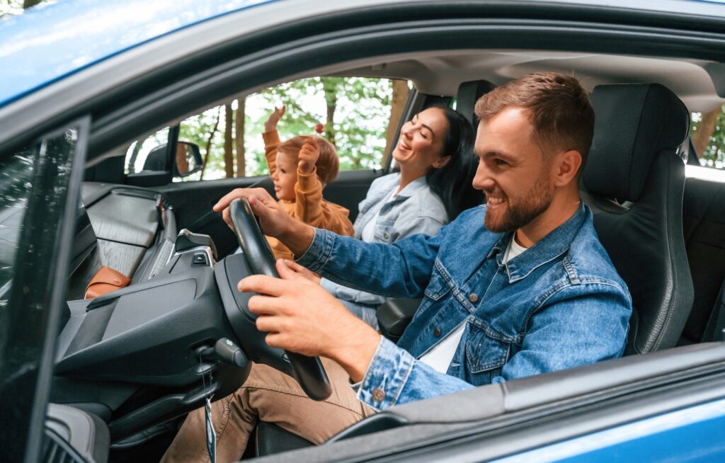 On a trip. Family of father, mother and little son are sitting in the modern car